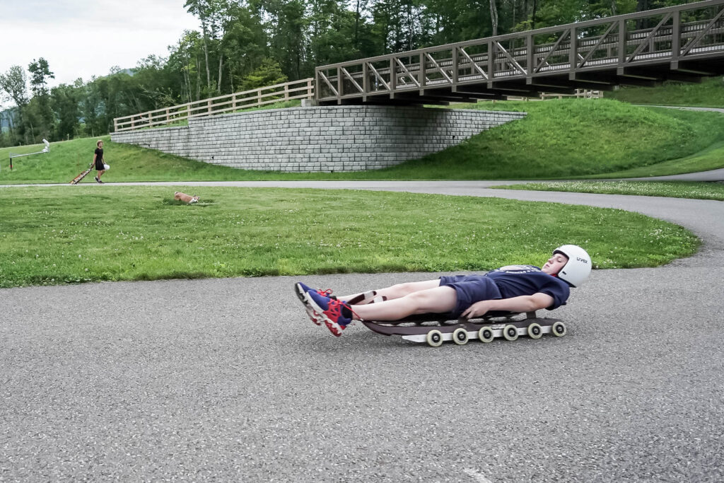 Brady slides on a wheeled sled.