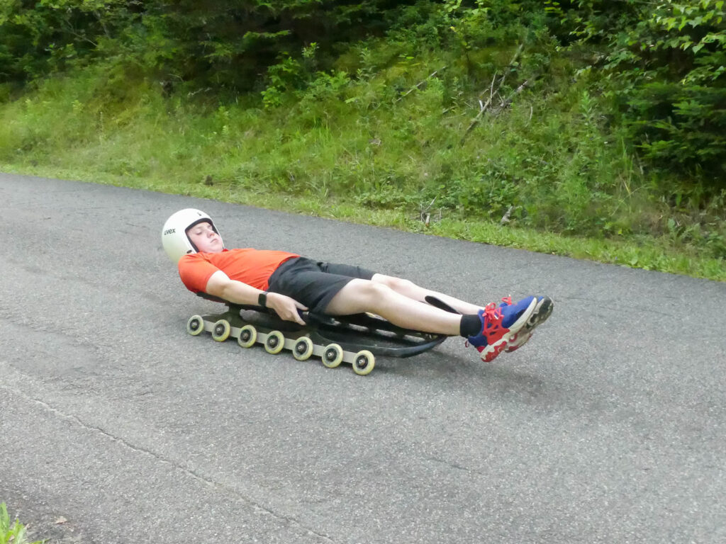 Brady sliding on a wheeled sled.